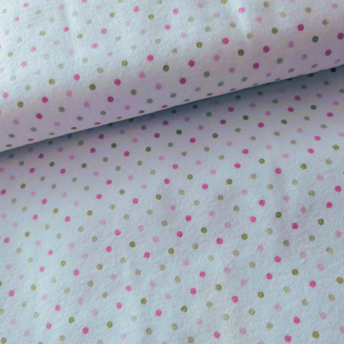 Robert Kaufman Cozy Cotton flannel fabric featuring scattered pink and green dots on a white background, soft two-ply cotton flannel for quilting and sewing projects.