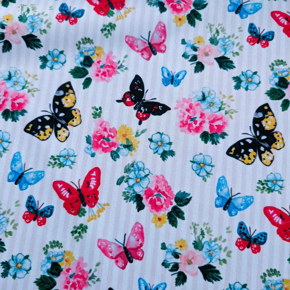 Colourful Butterfly Garden exclusive waterproof PUL fabric with blue, pink, red and yellow butterflies and flowers on yellow stripes