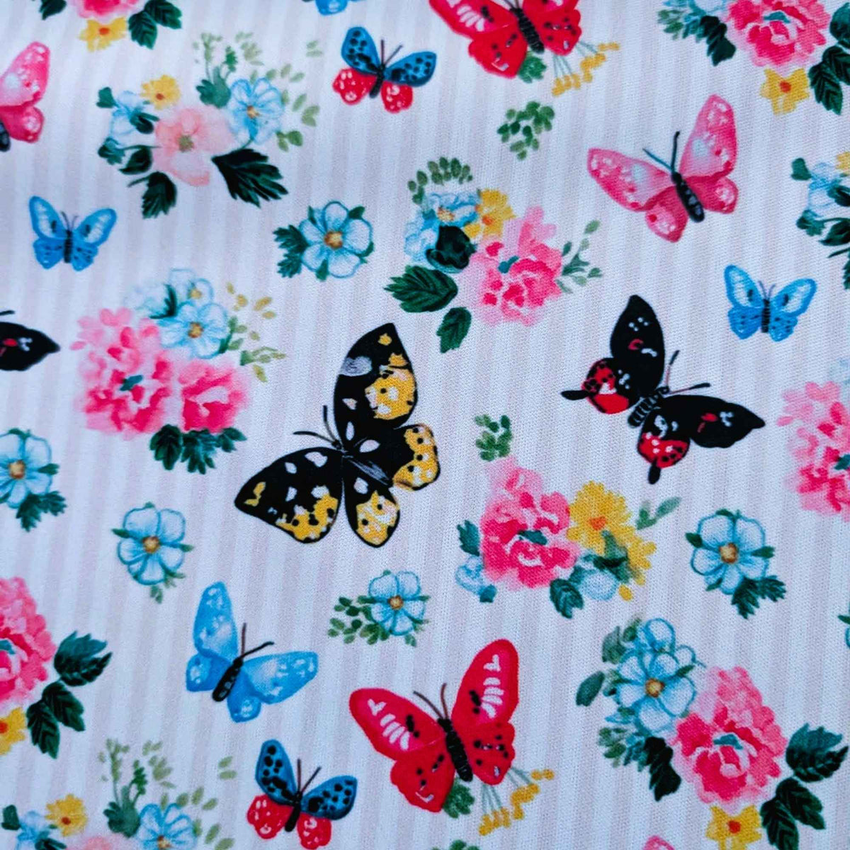 Colourful Butterfly Garden exclusive waterproof PUL fabric with blue, pink, red and yellow butterflies and flowers on yellow stripes