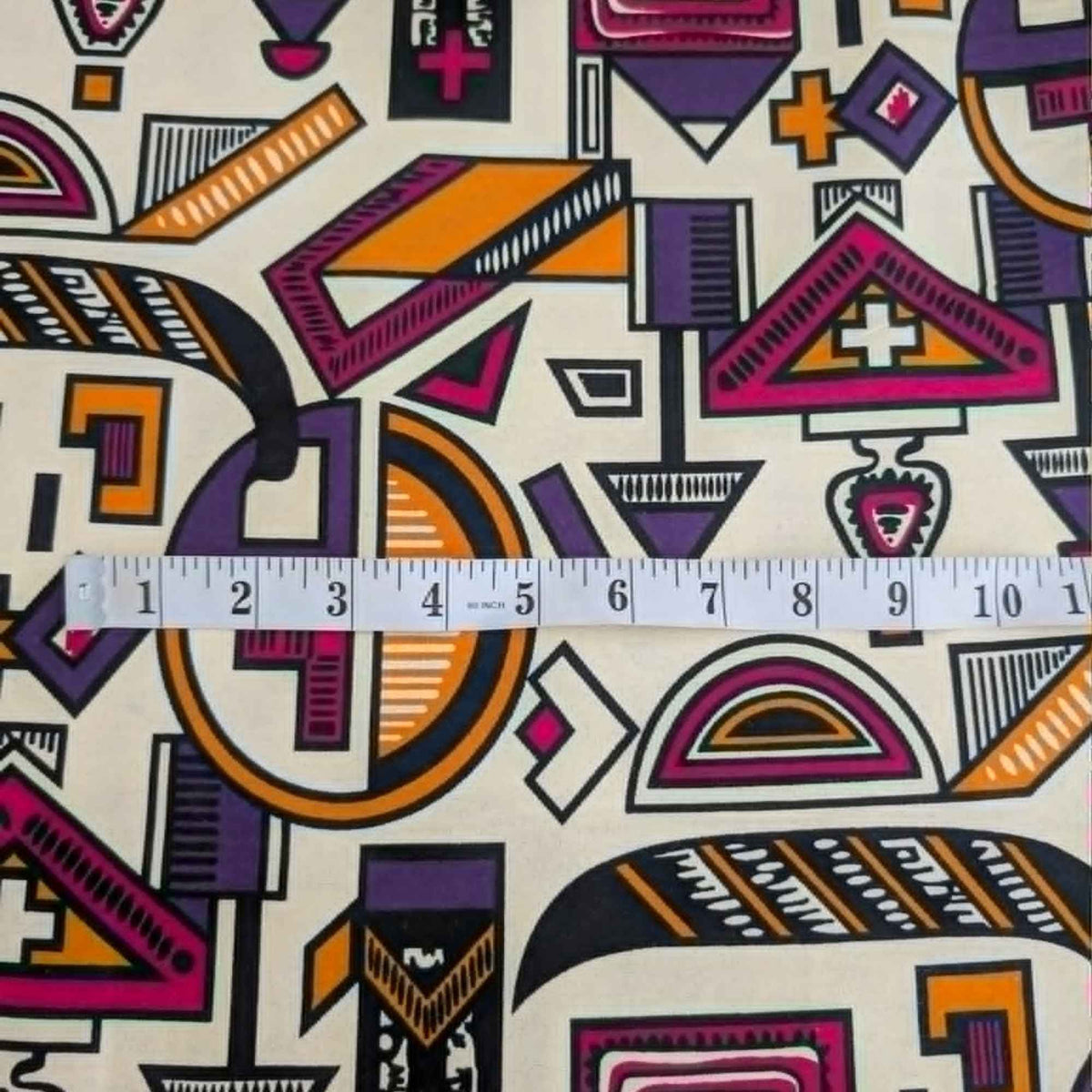 African-inspired geometric tribal double brushed flannel fabric featuring colorful abstract geometric symbols on a cream background.