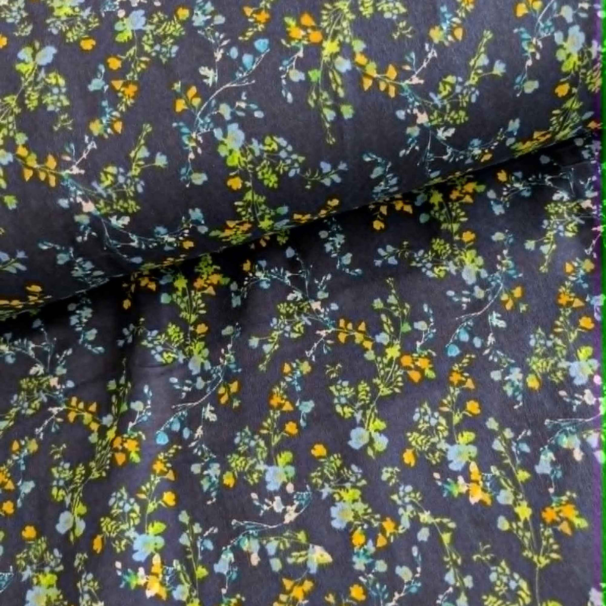 Double brushed flannel fabric featuring delicate yellow, blue, and green wildflowers with trailing vines on a navy background.