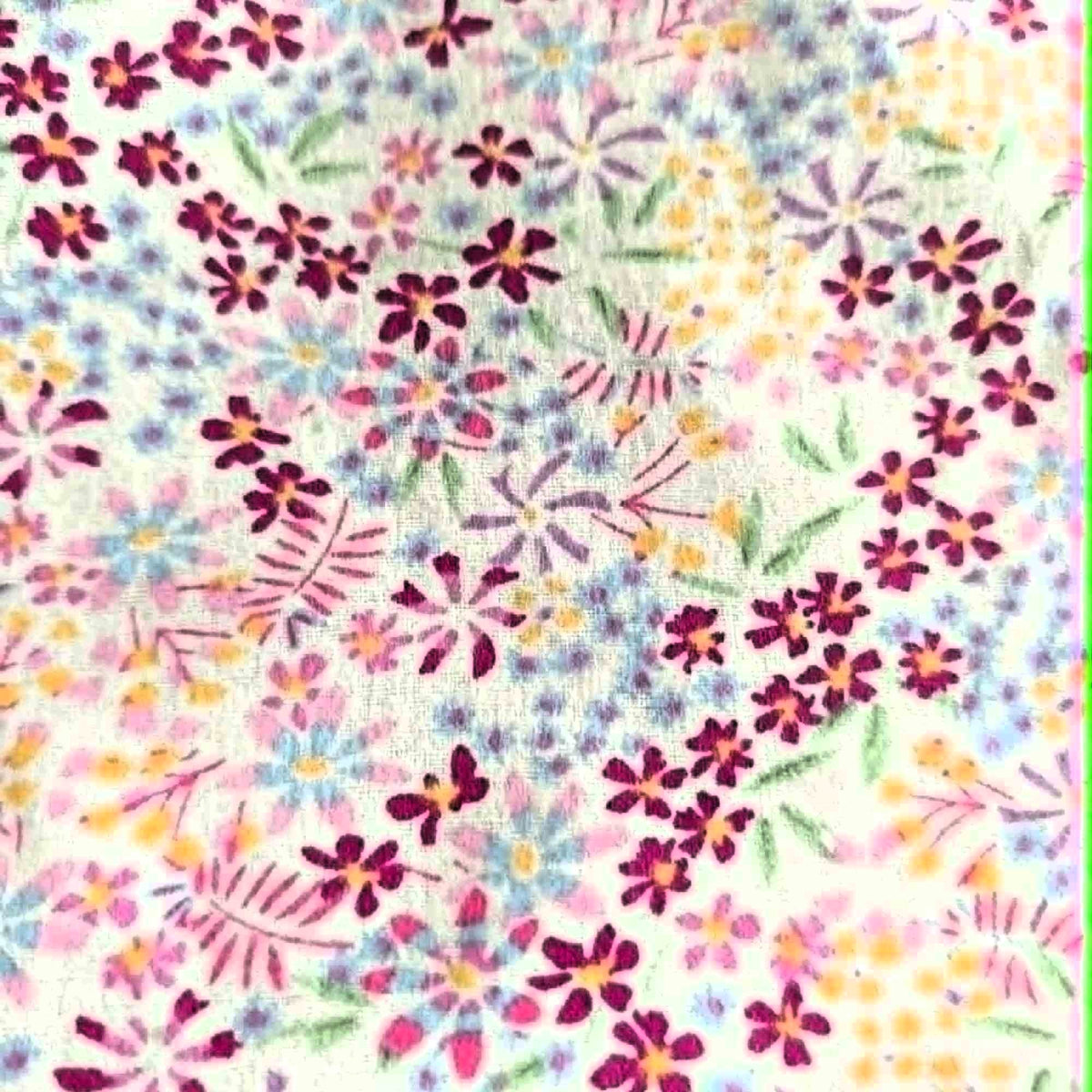 Double brushed flannel fabric featuring pastel wildflowers and delicate floral sprigs in pink, lavender, blue, yellow, and green on a white background.