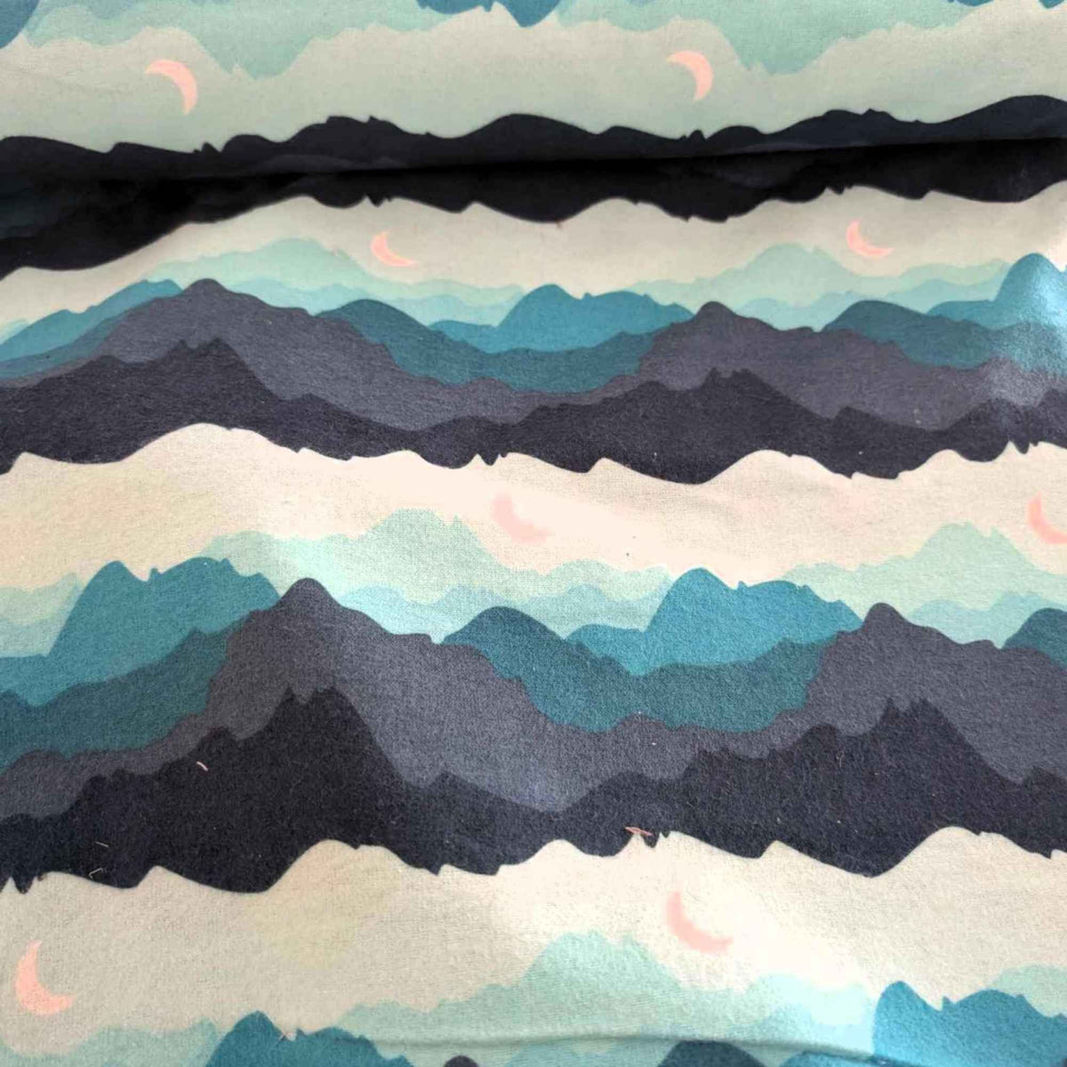 Teal, navy and grey mountain print flannel fabric with pink crescent moons