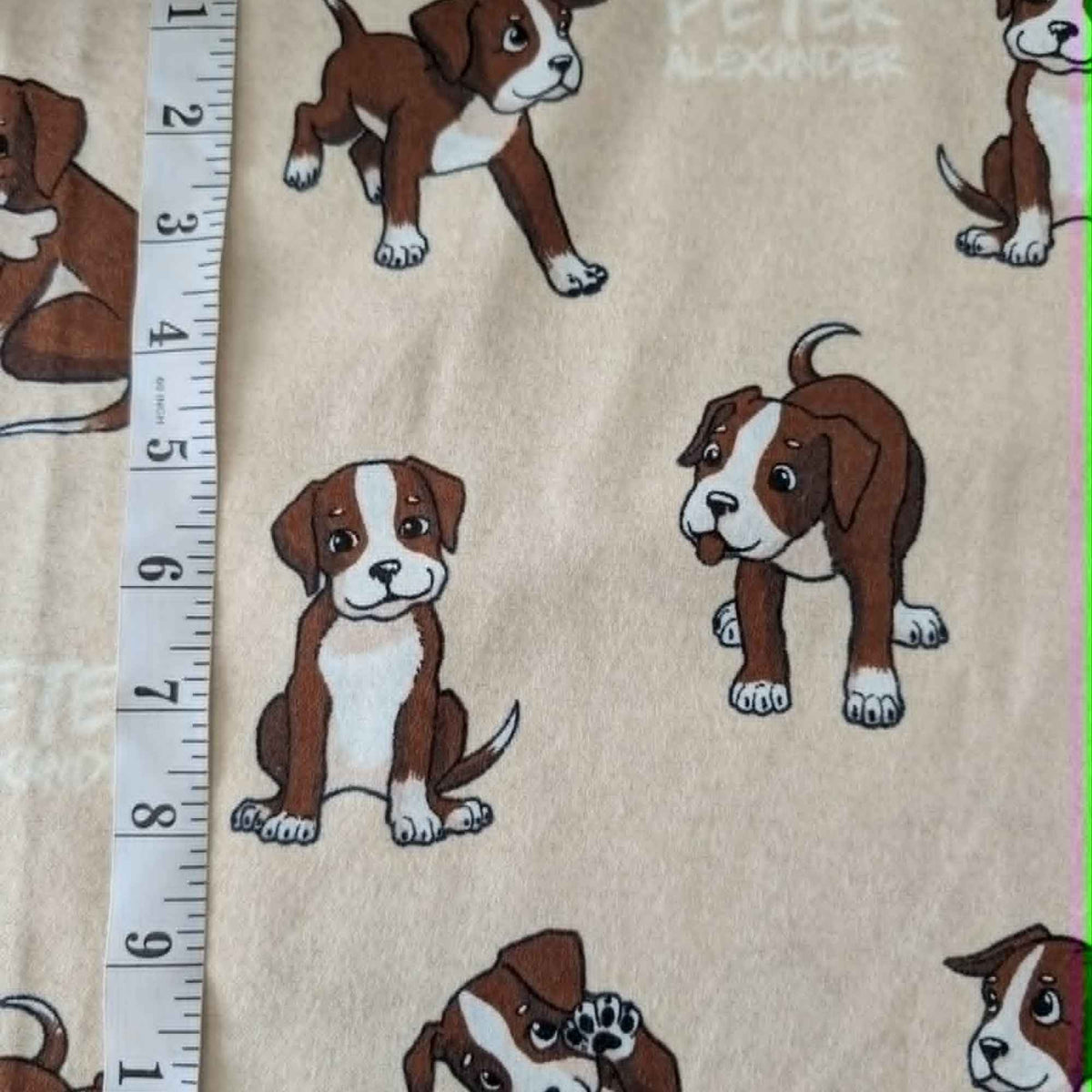 Double brushed flannel fabric featuring playful brown and white puppies in various poses on a cream background.