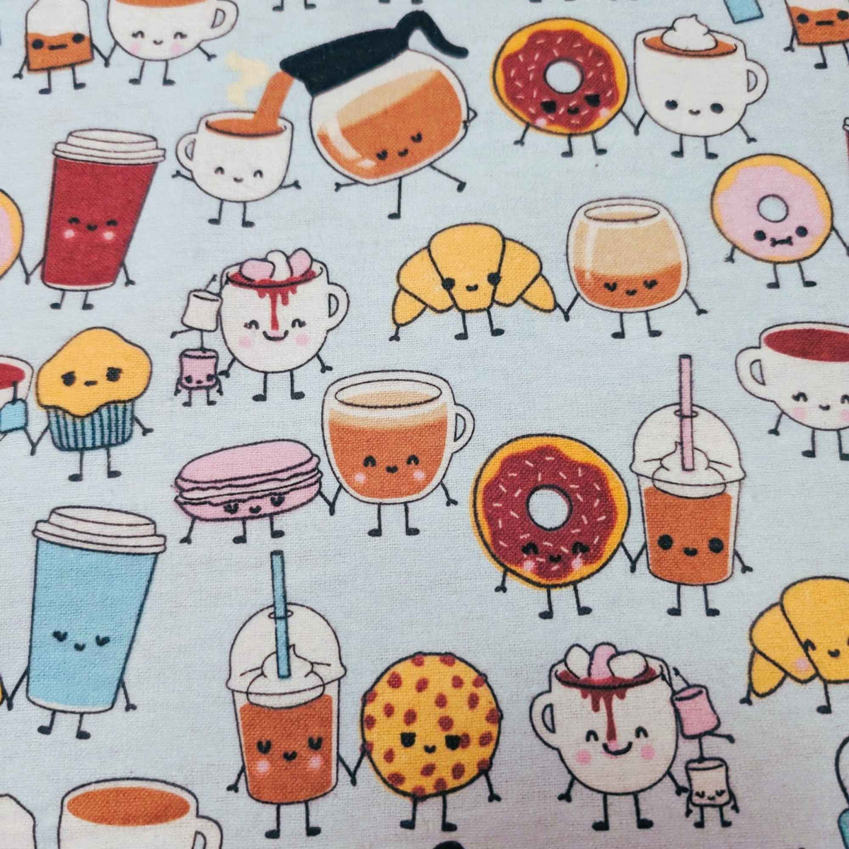 A close-up of a mint green fabric featuring a repeating pattern of cute, anthropomorphic food and drink characters, including coffee cups, donuts, a croissant, a macaroni, a muffin, and a cookie.