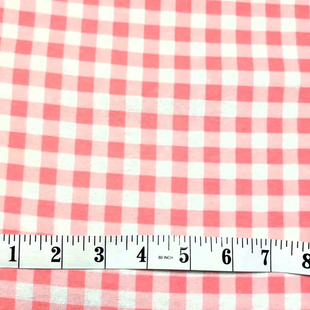 Red and white gingham checkered fabric shown with a 12-inch measuring tape along the bottom edge to indicate scale.