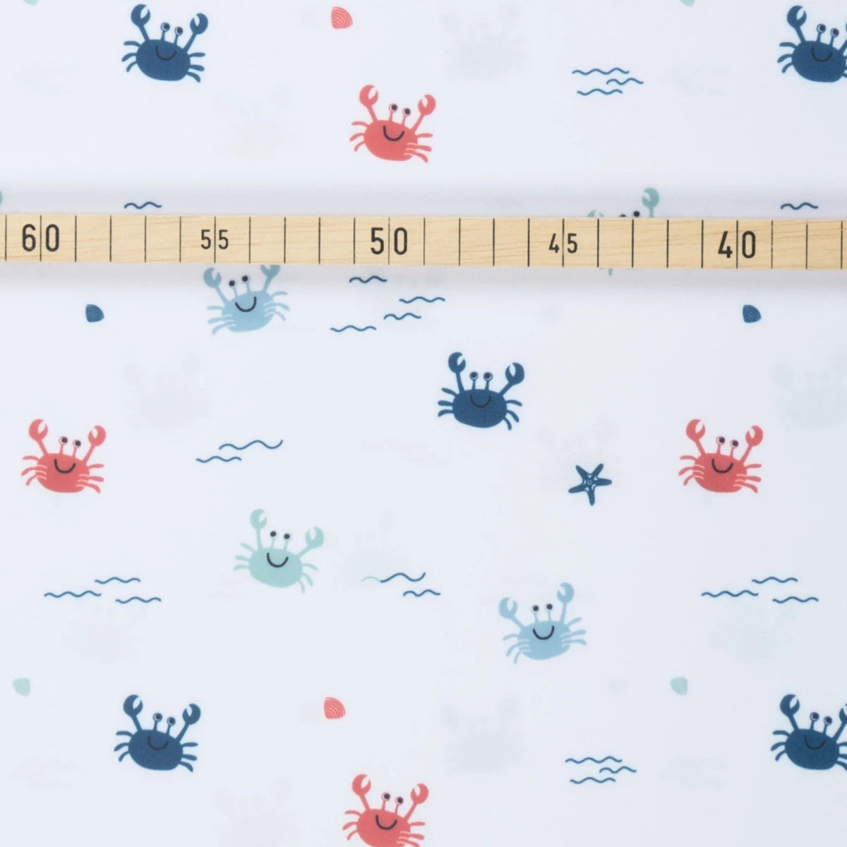 White swim fabric with playful red, blue, and mint crabs and beach motifs – Oeko-Tex certified stretch knit for kids' swimwear and ocean-themed projects