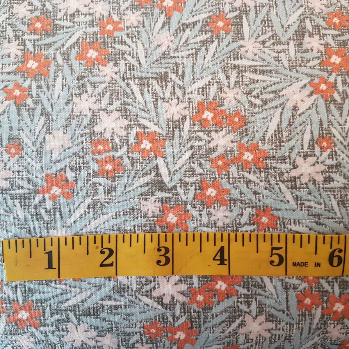 Orange Floral Cotton Fabric on Grey Textured Background