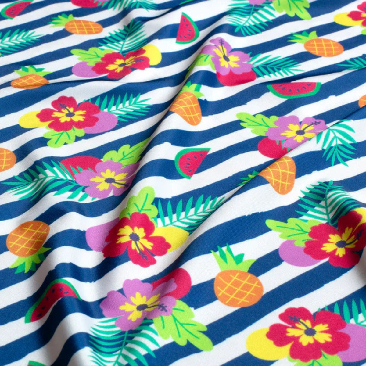 Bold tropical swim fabric with hibiscus flowers, pineapples, and fruit on navy and white stripes – Oeko-Tex certified stretch knit for swimwear and beachwear"